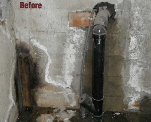 A dirty, damaged basement wall with stained concrete and a black pipe coming out, surrounded by mold, water damage, and debris—an ideal candidate for polyurethane grout injection. The word "Before" is written on the upper left of the image.