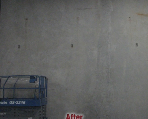 A blue Genie GS-3246 scissor lift is parked against a plain gray concrete wall, recently stabilized using polyurethane grout injection. The word "After" is written in red text at the bottom center of the image.