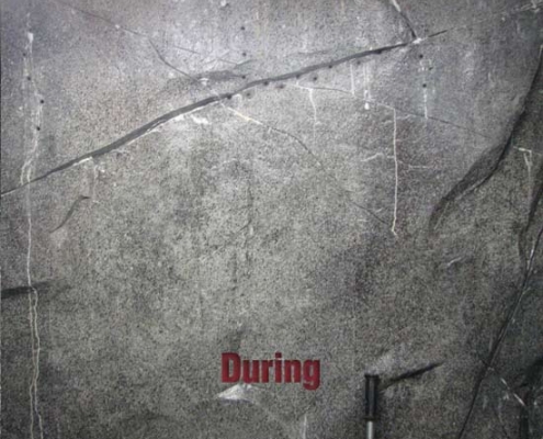 A gray, cracked wall with faint white streaks and the word "During" in red letters at the center, suggesting ongoing polyurethane grout injection. A handle or rod appears at the bottom right corner.