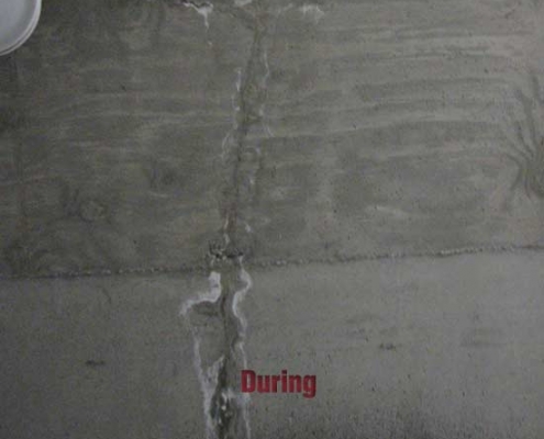 A concrete wall with visible cracks that have been partially repaired using polyurethane grout injection. The word "During" is written in red at the center, indicating the repair process is ongoing.
