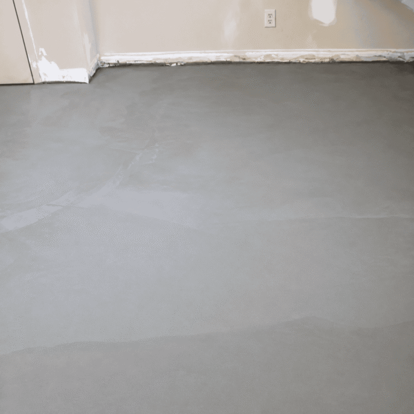 A room with smooth, freshly-leveled concrete flooring and unfinished walls, labeled "After" in red text at the bottom center.